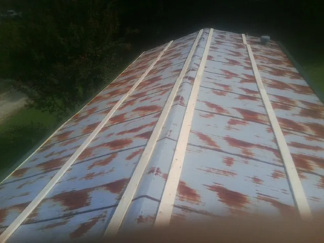 Rusted metal roof panels with new wood purlins before replacement — Storm Damage Roof Repair in Oakridge by Roofing Brothers