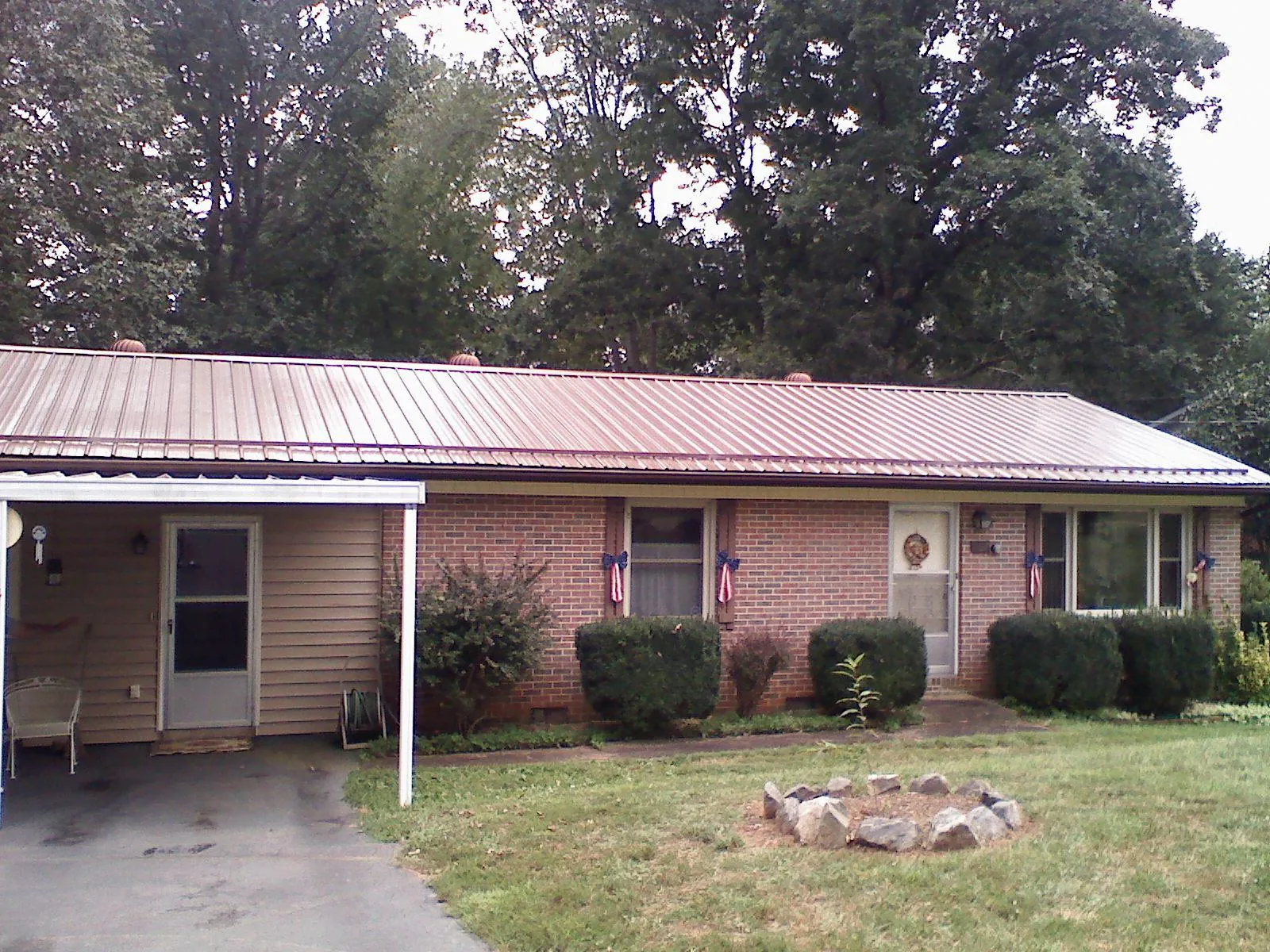 Bronze metal roof and carport on a brick ranch home — Roof Repair work by our crew in Oakridge
